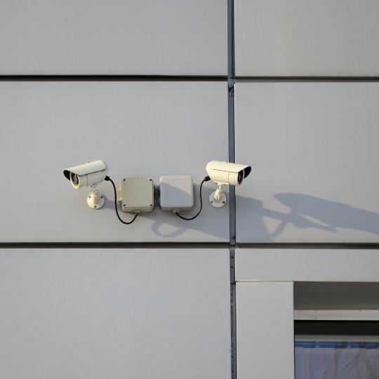 white-surveillance-camera-built-into-metal-wall-office-buildin.png